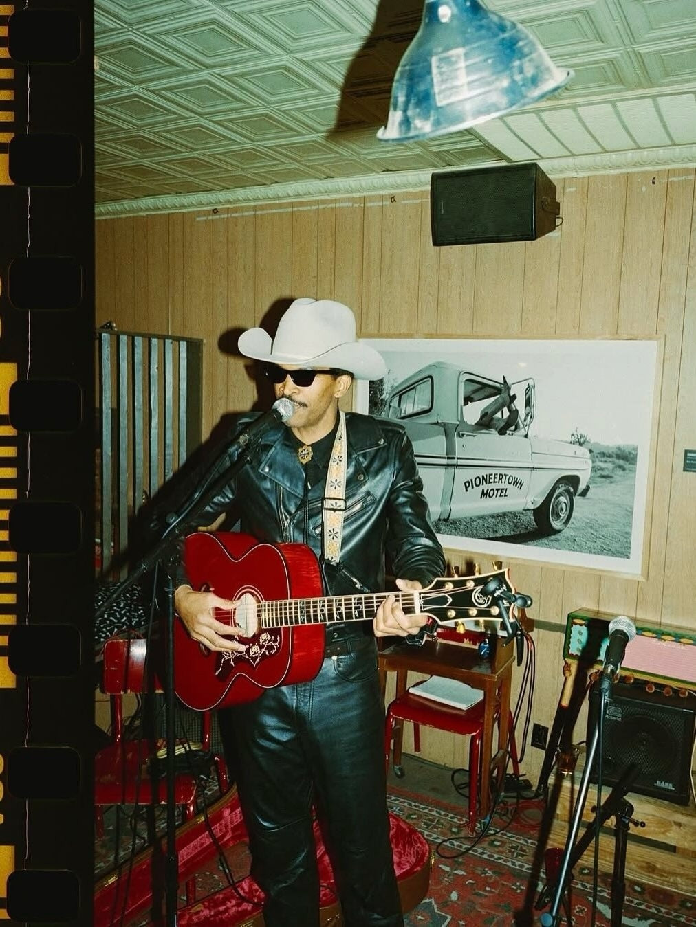 Pioneertown performance with a musician and framed photograph — owner-selected exhibition image