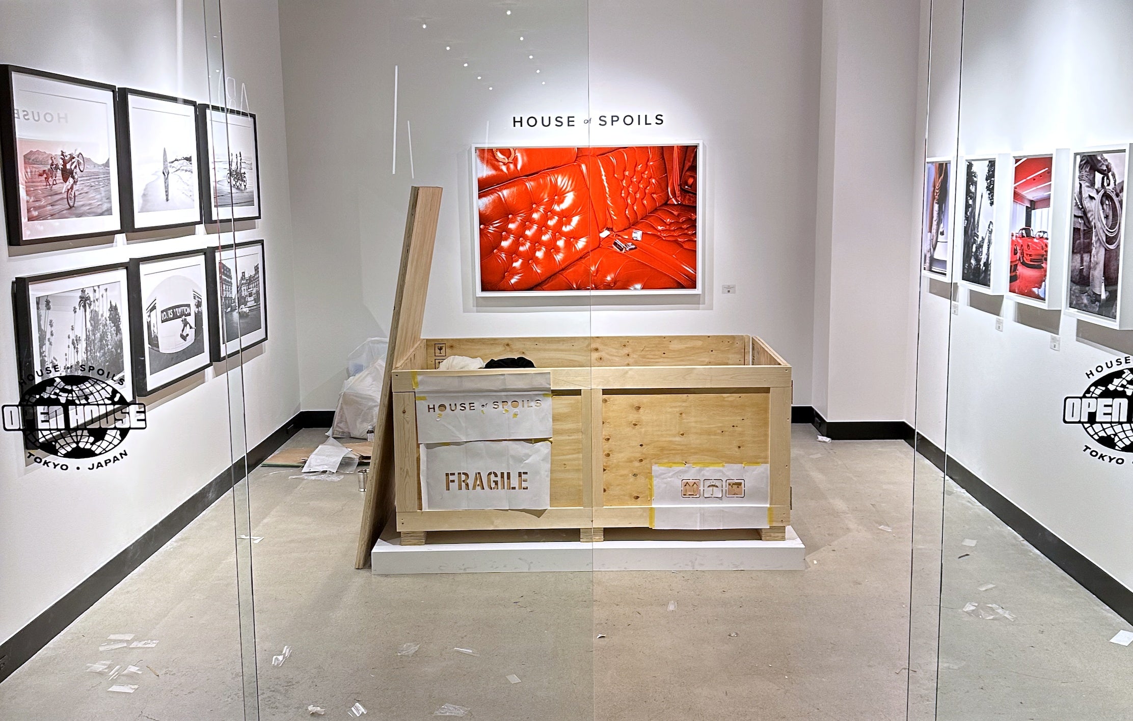 Tokyo gallery installation with framed photographs and a shipping crate — owner-selected exhibition image
